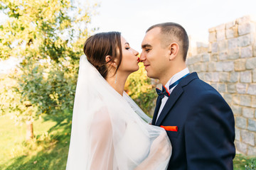 Wedding of a beautiful couple in nature.The bride is kissing the groom in the nose