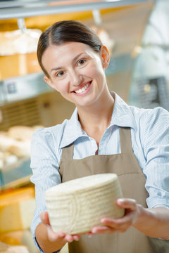 Woman holding a wheel of cheese