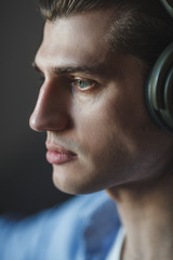 Music in his mind. Portrait of young man wearing headphones and looking away