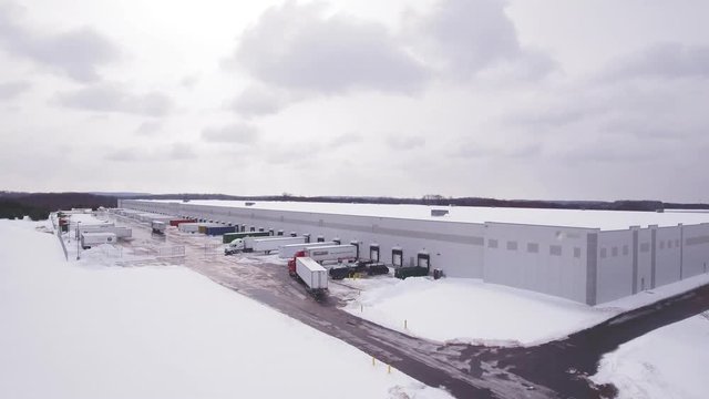 Aerial Semi truck filling up at warehouse in the snow