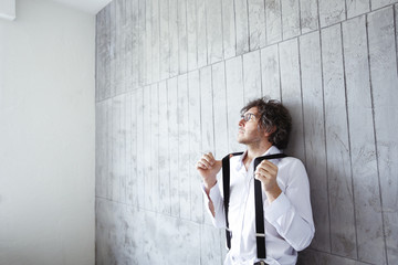 Architect leaning against concrete wall at construction site