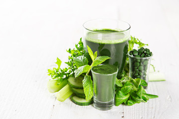 Healthy green smoothie in a glass with vegetables.