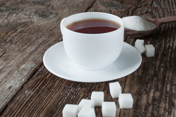 sweet cup of fruit tea with lemon and sugar on a wooden background
