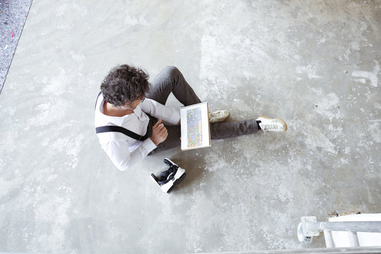 Architect with Virtual Reality Glasses and sketch book at construction site