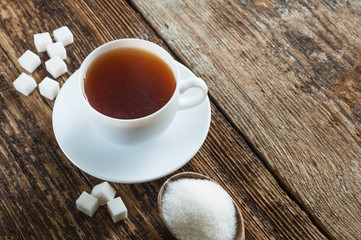 sweet cup of fruit tea with lemon and sugar on a wooden background