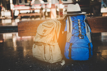 traveler backpack in train station and sunlight with vintage tone sunset background