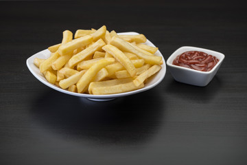 French fries on wooden chopping board with catchup and mustard sauce  