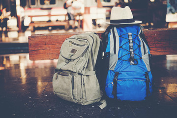 traveler backpack in train station and sunlight with vintage tone sunset background