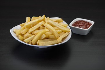 French fries on wooden chopping board with catchup and mustard sauce  