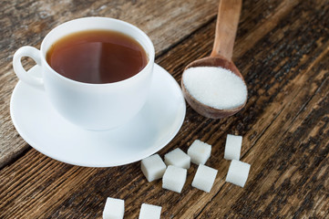 sweet cup of fruit tea with lemon and sugar on a wooden background
