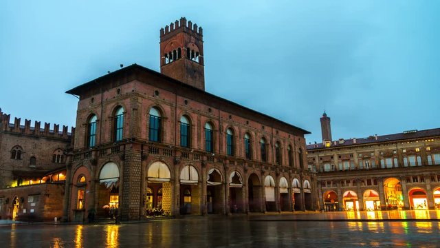 Bologna, Italy. King Enzo palace at the main square of Bologna, Italy. Famous landmark at sunset at night. Time-lapse during the rain
