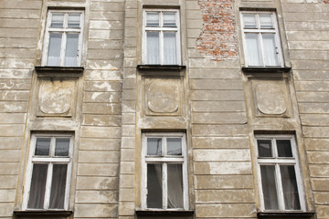 Six vintage  white windows on the facade of the ragged old house