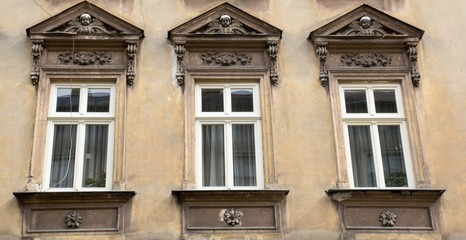 Fototapeta na wymiar Three vintage design windows on the facade of the old house