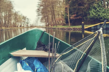 Poster Im Rahmen Fishing boat with fishing rods in a river © Robert Herhold