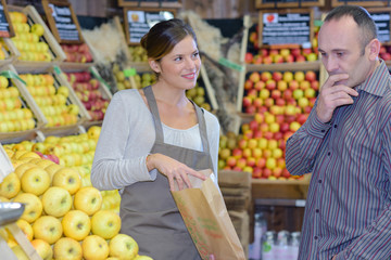 Man deliberating which apples to buy