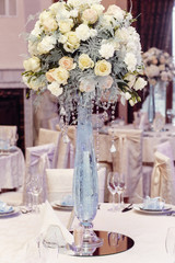 luxury wedding decor with flowers of roses and hydrangea closeup in glass vases with jewels. arrangements decorations at wedding reception. expensive catering. space for text