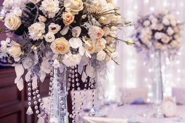 Obraz na płótnie Canvas luxury wedding decor with flowers of roses and hydrangea closeup in glass vases with jewels. arrangements decorations at wedding reception. expensive catering. space for text