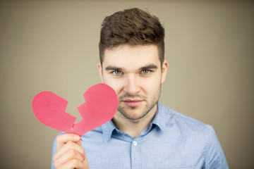 Sad man holding broken heart card
