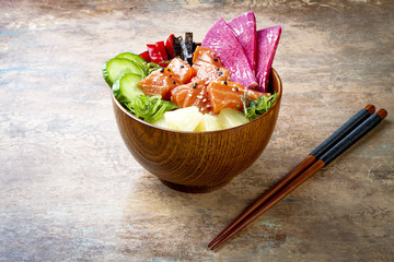 Hawaiian salmon poke bowl with seaweed, watermelon radish, cucumber, pineapple and sesame seeds....