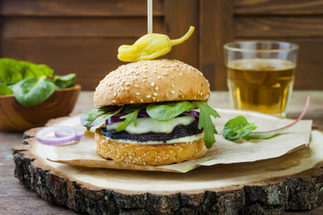 Grilled portobello mushroom burger. Healthy veggies hamburger with onions, arugula, cheese, spicy pickled hot peppers and tartar sauce. Copy space background