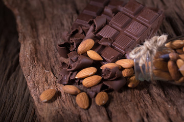 Chocolate bar pieces. large bar of chocolate and Almond nuts on wooden background