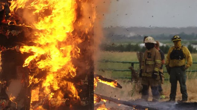 Firemen watching house burn during controlled burn