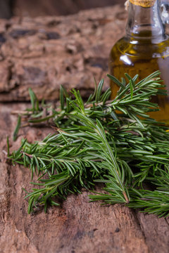 rosemary Herbs and Medicinal herbs. fresh rosemary bunch and oil on wooden background