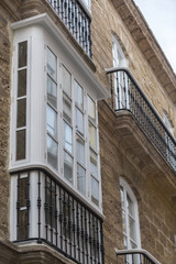 Detail of balconies and large windows on the time of the nineteenth century, Narrow street with traditional architecture in Cadiz, Andalusia, southern Spain