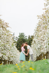 Verliebtes Paar steht in blühender Baumallee und schaut sich an