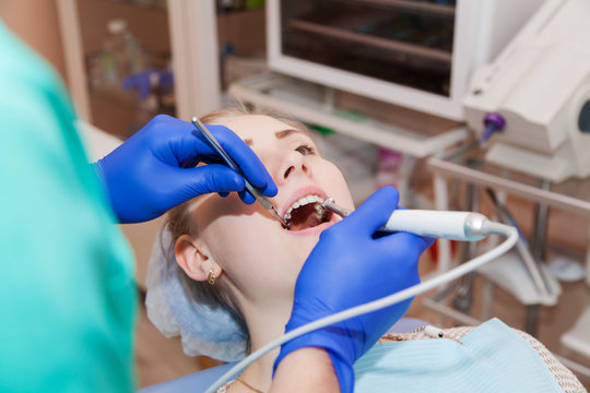 Dentist at work cures teeth to woman
