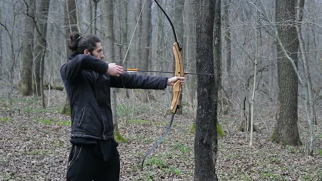 Man shoot with a bow in the forest