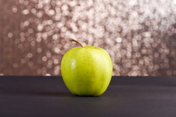 fresh green apple on grey table, sparkling background