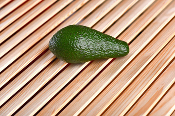 fresh green avocado on brown wooden table, sparcling background