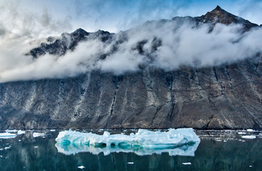 Iceberg and cliffs with low cloud, Karrat Fjord, Greenland © Dennis