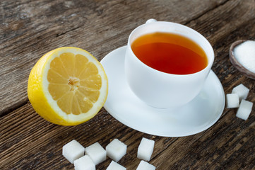 sweet cup of fruit tea with lemon and sugar on a wooden background