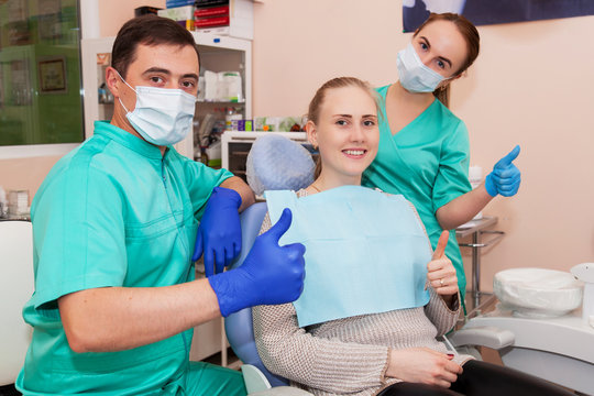 Happy two dentists and a patient, after dental treatment