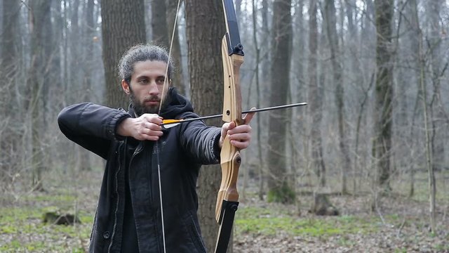 Man shoot with a bow in the forest