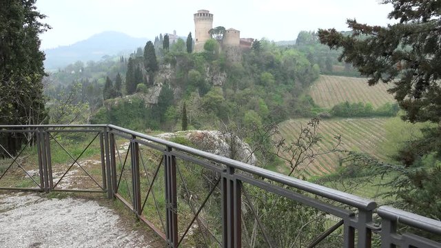 parapet on view of ancient castle and Catholic church in green valley of Romagna in Italy