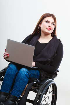 Disabled woman with laptop on wheelchair.