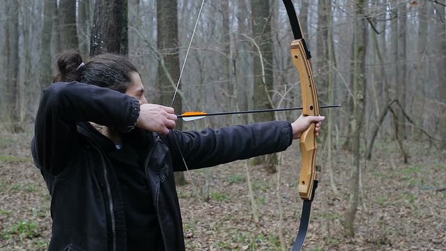 Man shoot with a bow in the forest