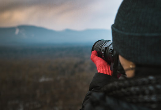 Girl photographer takes pictures of a magnificent mountain landscape