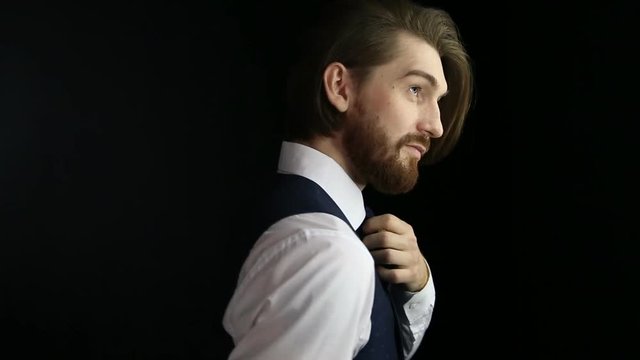 Young European hipster with fair skin and trendy ginger beard posing for photographer. Handsome man with fashionable undercut hairstyle posing during photo shoot.