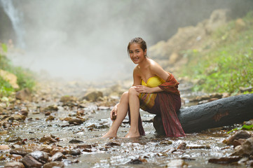 young woman relaxing in hot springs,Woman enjoy onsen in Thailand,Asian woman wearing traditional thai take a baht hot sping on during sunset,vintage style,Beautiful woman take a baht