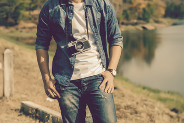 Young man tourist standing and taking photos with vintage camera.