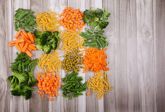 Carrots, broccoli, beans, paste on a wooden background