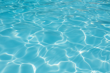 Blue and bright ripple water and surface in swimming pool , Beautiful motion gentle wave in pool
