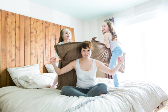 Young Mother And Childs On Morning Yoga Exercises In Bed