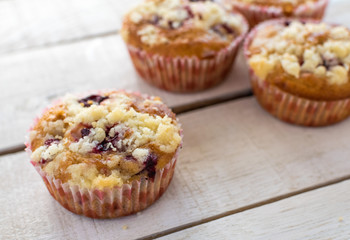 Cherry muffins on white wooden background..