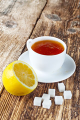 sweet cup of fruit tea with lemon and sugar on a wooden background