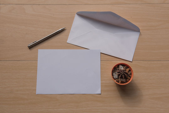 Envelope and White paper and pen on wooden background .